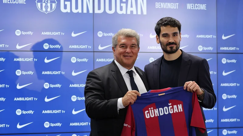Predsednik Barcelone Joan Laporta in novi nogometaš kluba Ilkay Gündogan. FOTO: Lluis Gene/AFP
