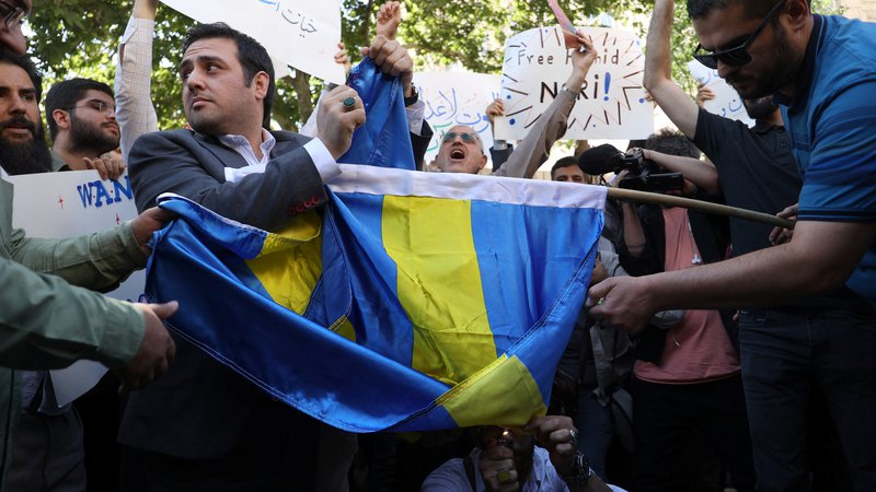 Fotografija: Protestniki v Iranu zažigajo švedske embleme. FOTO: Reuters
