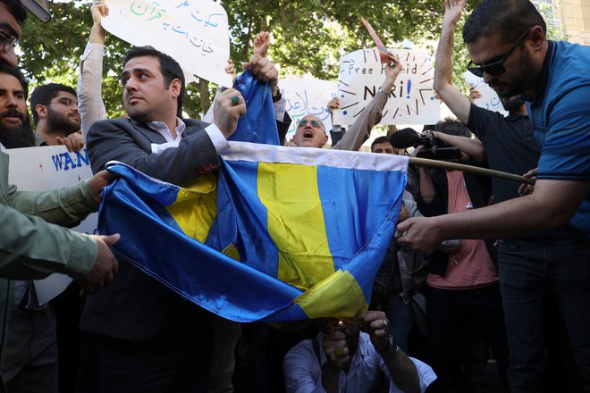 Protestniki v Iranu zažigajo švedske embleme. FOTO: Reuters