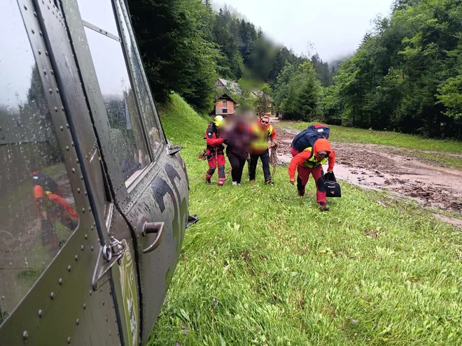 Iz naselja Sv. Barbara v občini Škofja Loka so se gorska reševalca GRS Škofja Loka in gasilec čez neprehoden teren uspešno prebili do nosečnice in jo skupaj z združeno ekipo GRZS - HNMP in helikopterjem Slovenske vojske prepeljali v ljubljansko porodnišnico. FOTO: GRZS In Slovenska Vojska