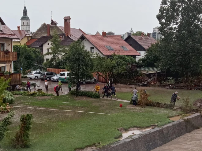 Poljanska Sora se je vrnila v strugo, ljudje ji vračajo, kar jim je naplavila. Foto Vojko Urbančič