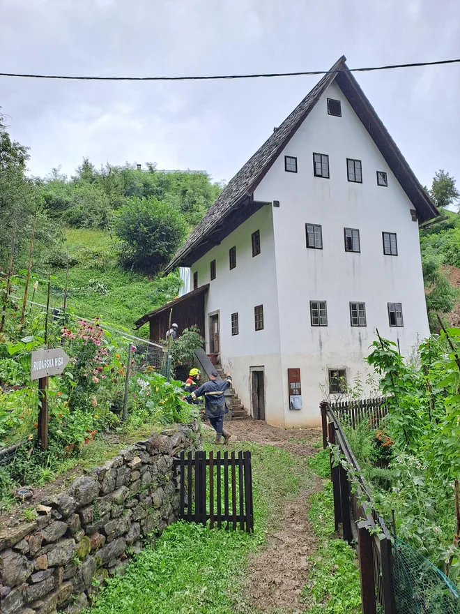 Pri sanaciji plazu nad hišo in pri čiščenju okolice objekta so združili moči muzejski delavci in prostovoljni gasilci. FOTO: Anja Intihar/Delo