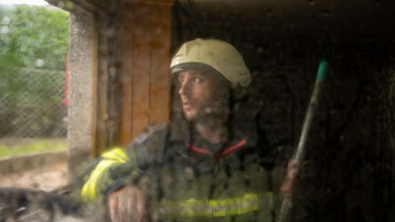 Fotografija: Gasilec med intervencijo zaradi poplav v Mostah pri Komendi. FOTO: Voranc Vogel/Delo