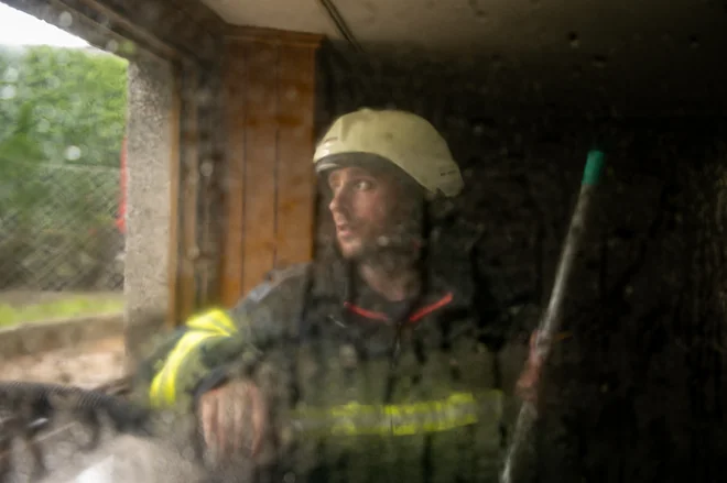 Gasilec med intervencijo zaradi poplav v Mostah pri Komendi. FOTO: Voranc Vogel/Delo