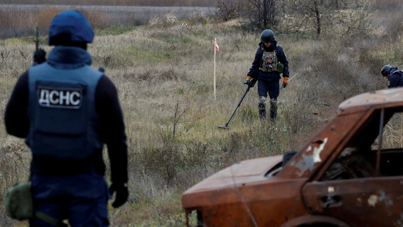 Ukrajinski vojaki preiskujejo minsko polje ob cesti proti Hersonu. FOTO: Murad Sezer/Reuters