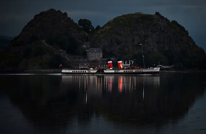 Mimo gradu Dumbarton na reki Clyde pelje parnik Waverley. Waverley je bil zgrajen leta 1946 in je bil zadnji morski parnik na svetu, ki je prevažal potnike, leta 1973 pa je bil umaknjen iz rednega prometa in po obnovi zdaj opravlja sezonske izletniške storitve. Foto: Paul Ellis/Afp