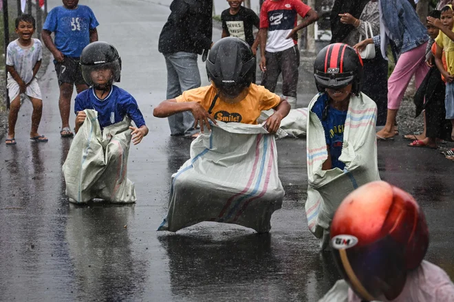 V vasi Nusa v indonezijski provinci Acehso so včeraj otroci tekmovali v tradicionalni dirki z vrečami med praznovanjem 78. dneva neodvisnosti. Foto: Chaideer Mahyuddin/Afp