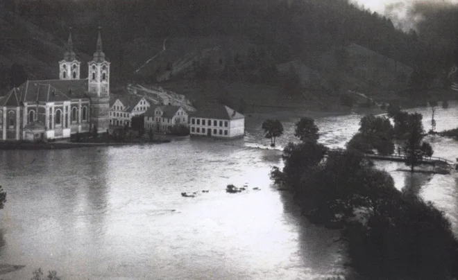 26., 27. in 28. septembra 1926 so se od Trsta do Maribora trgali oblaki in povzročali vodne ujme. Na 600 kvadratnih kilometrih je v teh treh dneh padlo povprečno sto litrov dežja na kvadratni meter; 60 milijonov kubičnih metrov vode, ki je morala odteči v kakih 24 urah. Največ padavin je bilo v Trstu, Biljah pri Gorici, Idriji, žirovsko-polhograjskem svetu, na Kamniškem, v Zasavju in Mariboru, posledice pa so bile najhujše na Žirovskem, v Poljanski dolini, Polhograjskih dolomitih in tudi v Ljubljani; Na Viču in v Rožni dolini je voda segla do dva metra visoko. Na fotografiji farna cerkev in stara šola v Žireh med pobesnelimi vodotoki Žirovske kotline. FOTO: Dokumentacija Dela