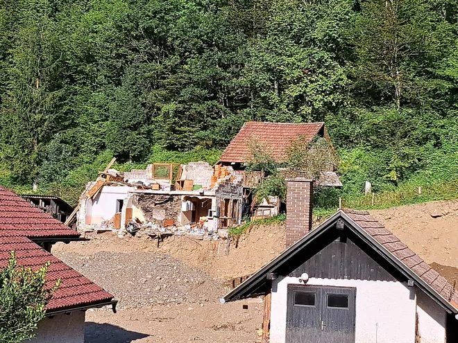 Iz hiše, od katere ni ostalo veliko, sta komaj pobegnila mati in sin, ki obiskuje prvo triado osnovne šole. FOTO: Špela Kuralt/Delo