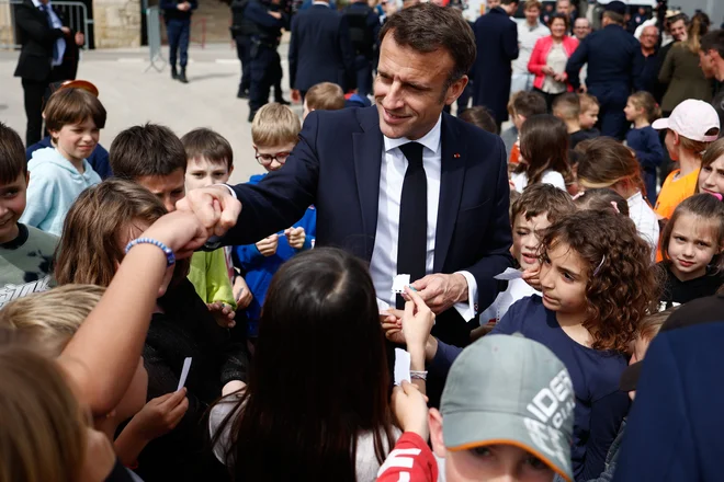 Francoski predsednik Emmanuel Macron med šolarji. FOTO: Raphael Lafargue/Afp