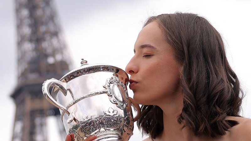 Fotografija: Poland's Iga Swiatek kisses the trophy Suzanne Lenglen during a photocall, with the Eiffel Tower in background, a day after winning the women's singles final match against Czech Republic's Karolina Muchova of the Roland-Garros Open tennis tournament in Paris, on June 11, 2023. (Photo by Thomas SAMSON / AFP)