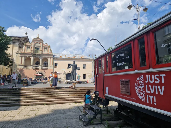 V prodajalno s turističnimi spominki preurejen vagon tramvaja. V ozadju tržnica rabljenih knjig in spomenik menihu Ivanu Federovu, ki je v 16. stoletju začel tiskati knjige v Ukrajini.