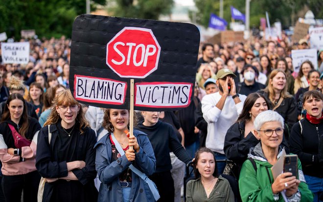 Z napisi 'Nehajte kriviti žrtve' so protestniki julija na shodu pred dunajskim stadionom Ernsta Happla zahtevali, da skupina Rammstein odpove načrtovane koncerte. FOTO: Georg Hochmuth/AFP