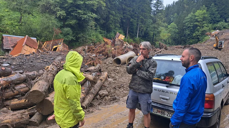Bernardi Breznik Krajnc in Petru Krajncu je plaz odnesel hišo. Od nje je ostalo, kar se vidi v daljavi. Med njima stoji Primož Planovšek. FOTO: Špela Kuralt/Delo