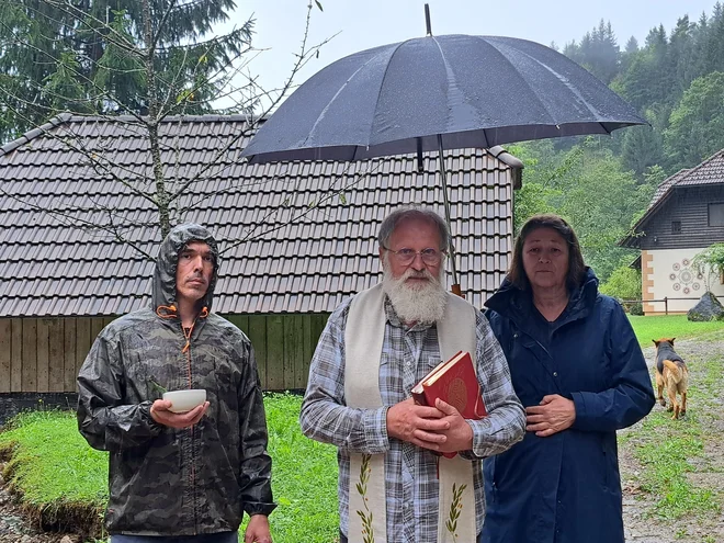 Ti avtomobili bodo vedno nosilci dobrega, je pater Karel Gržan blagoslovil vozila prostovoljcev. Ob Gržanu stojita Primož Planovšek in Violeta Bulc, Gržanova soseda. FOTO: Špela Kuralt/Delo