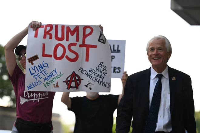 Peter Navarro, svetovalec nekdanjega predsednika ZDA Donalda Trumpa, se sprehaja mimo protestnikov pred sodiščem E. Barretta Prettymana v Washingtonu po izboru porote v primeru napada na Kapitol. Foto: Andrew Caballero-reynolds/Afp