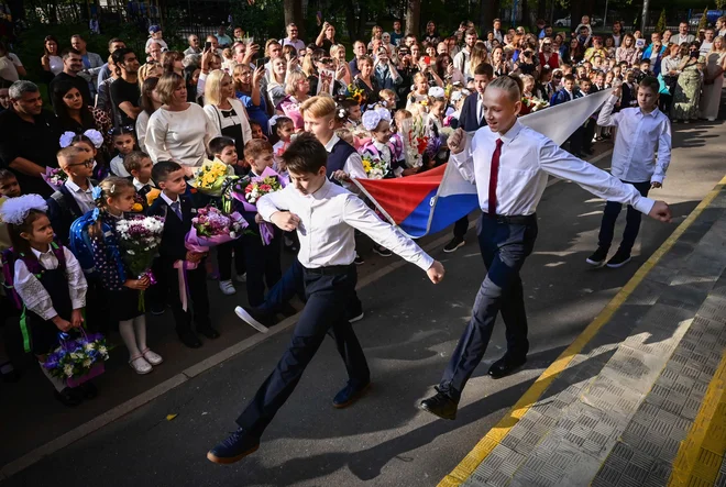 V Rusiji imenujejo 1. september dan znanja. Šolsko leto se tradicionalno začne s posebno slovesnostjo, imenovano prvi zvonec. Na fotografiji prizor z ene od moskovskih šol. FOTO: Yuri Kadobnov/AFP