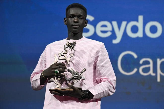 »Hvala vsem, se opravičujem... res sem brez besed,« je bil ob podelitvi nagrade presenečen mladi Senegalec Seydou Sarr. FOTO: Tiziana Fabi/AFP