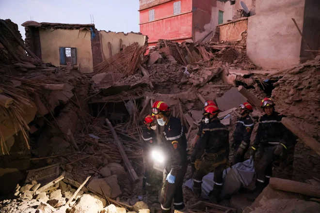 Reševalne ekipe med odstranjevanjem smrtnih žrtev potresa iz ruševin v Amizmizu v Maroku FOTO:  Nacho Doce/Reuters