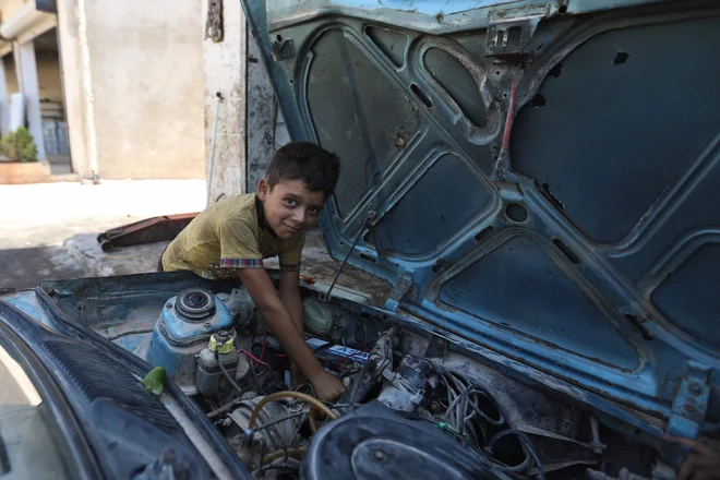 Deček dela v avtomehanični delavnici namesto da bi hodil h pouku v vasi Killi v sirski severozahodni provinci Idlib, ki je pod nadzorom upornikov. Foto: Aaref Watad/Afp