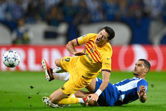 Igralec Porta David Carmo je s svojim posredovanjem povzročil poškodbo gležnja člana Barcelone Roberta Lewandowskega. FOTO: Patricia De Melo Moreira/AFP