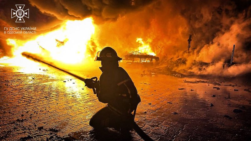 Fotografija: Ukrajinski gasilec pri gašenju infrastrukture, ki je zagorela po ruskem napadu v Odesi. FOTO: Handout Afp