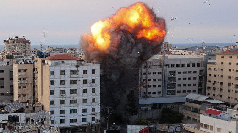 Fotografija: Ogenj in dim se dvigujeta po izraelskem zračnem napadu na Narodno banko v Gazi. FOTO: Ahmed Zakout/AFP