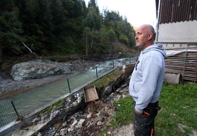 Božo Robnik ima ob hiši tudi mizarstvo, škarpa je padla pod pobesnelo Savinjo: »Niti enega stroja še ni bilo tu! Tu je tri metre zasuto s prodom, pa niti en kamion še ni nič odpeljal.« FOTO: Dejan Javornik
