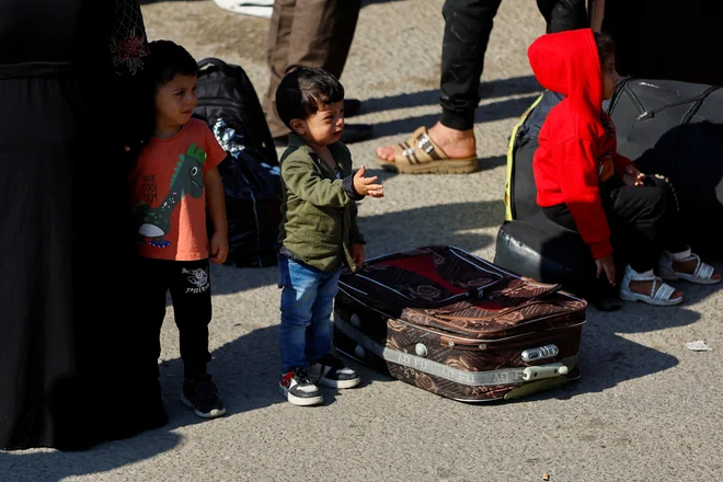 Palestinski otroci pri mejnem prehodu Rafa. FOTO: Ibraheem Abu Mustafa/Reuters