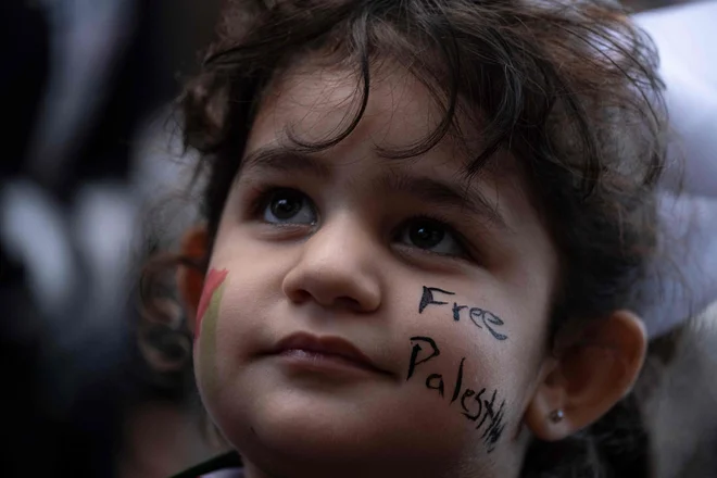 Deklica ima na obrazu napis »Svobodna Palestina« na demonstracijah v podporo Palestincem v San Juanu v Portoriku. Protesti v podporo Palestini potekajo po vseh večjih mestih po svetu. Foto: Ricardo Arduengo/Afp