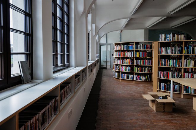 Tudi v knjižnici, kjer se police že polnijo, je mogoče videti rekonstruiran prvotni tlak iz borovih kock. FOTO: Črt Piksi