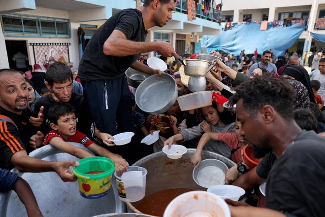 Palestinski otroci prejemajo hrano v šoli pod okriljem ZN v Rafi na jugu Gaze 23. oktobra 2023 med nenehnimi spopadi med Izraelom in Hamasom. Foto: Mohammed Abed/Afp