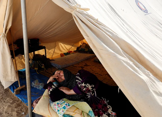 Palestinka, ki je zapustila svoj dom med izraelskimi napadi, je tako 23. oktobra počivala v šotorišču v Han Junisu na jugu Gaze, ki ga upravljajo Združeni narodi. FOTO: Mohammed Salem/Reuters