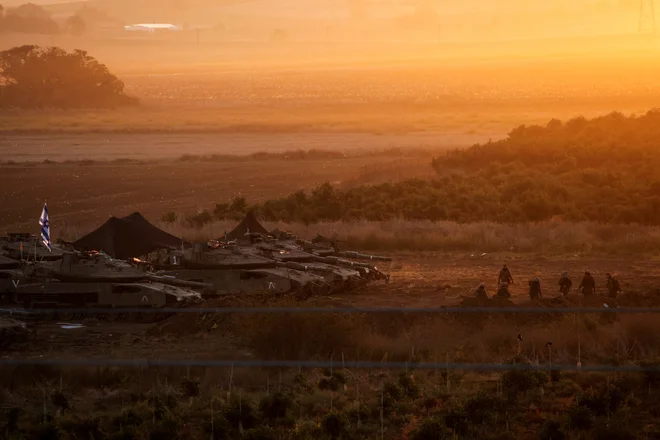 Izraelska vojska je ob mejah Gaze nakopičila desettisoče vojakov in ogromno svojih oklepnih vozil, s sodobnimi tanki merkava na čelu, a v kopensko ofenzivo še ni krenila. FOTO: Violeta Santos Moura/Reuters