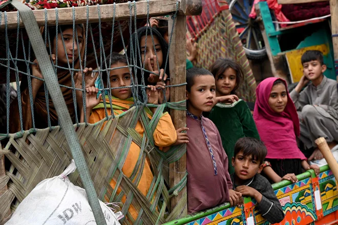 Afganistanski begunci prihajajo s tovornjaki iz Pakistana na afganistansko-pakistansko mejo Torkham v provinci Nangarhar. Islamabad je v začetku oktobra postavil ultimat 1,7 milijona Afganistancem, ki po njegovem mnenju nezakonito živijo v Pakistanu: zapustijo ga do 1. novembra ali pa jih čaka aretacija in izgon. Foto: Wakil Kohsar/Afp