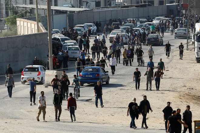 Palestinski delavci, ki so bili v času Hamasovih napadov v Izraelu, so prispeli na mejni prehod Rafa, da se bodo vrnili v Gazo. FOTO: Ibrahim Abu Mustafa/Reuters