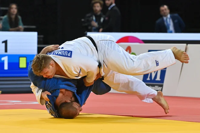 Finski orjak Martti Puumalainen (v belem kimonu) je v finalu ugnal Gruzinca Gurama Tušišvilija. FOTO: Sylvain Thomas/AFP