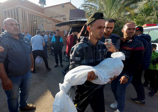 V napadu na stanovanjsko poslopje v mestu Kan Junis na jugu Gaze je umrlo najmanj 26 ljudi, še 23 so jih sprejeli zaradi hujših poškodb, je sporočil direktor tamkajšnje bolnišnice FOTO: Mohammed Salem/Reuters