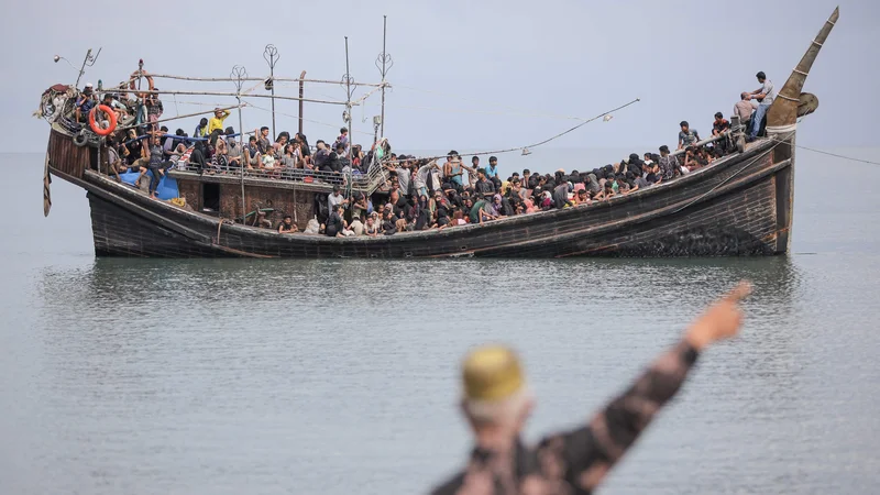 Fotografija: Novoprispeli begunci Rohinga so obtičali na čolnu, saj se je bližnja skupnost odločila, da jim ne bo dovolila izkrcanja, potem ko jim je dala vodo in hrano v Pineung. V indonezijsko provinco Aceh je v zadnjem tednu z najmanj petimi plovili prispelo več kot 800 beguncev etnične manjšine brez državljanstva, ki je v Burmi močno preganjana. Foto: Amanda Jufrian/Afp