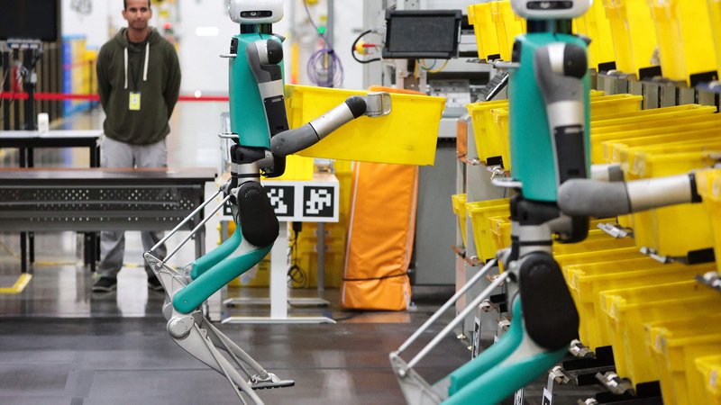 Fotografija: Logistična družba Amazon v svojih skladiščih testira robote, ki potiskajo vozičke. FOTO: Jason Redmond/AFP