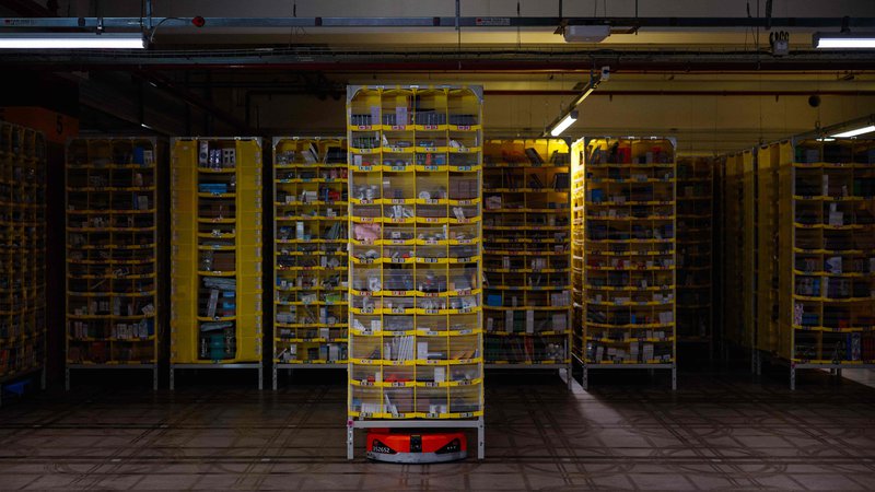 Fotografija: Velikan spletne prodaje Amazon v svojih skladiščih že uporablja regale, ki se premikajo z avtonomnimi robotskimi vozili. FOTO: Dimitar Dilkoff/AFP