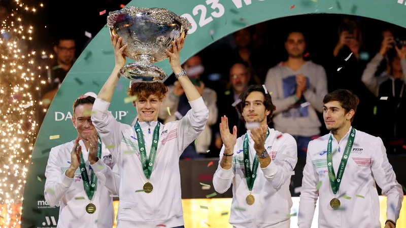 Jannik Sinner je takole dvignil veliki pokal za italijansko zmagoslavje v Davisovem pokalu. FOTO: Violeta Santos Moura/Reuters