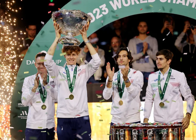 Jannik Sinner je takole dvignil veliki pokal za italijansko zmagoslavje v Davisovem pokalu. FOTO: Violeta Santos Moura/Reuters