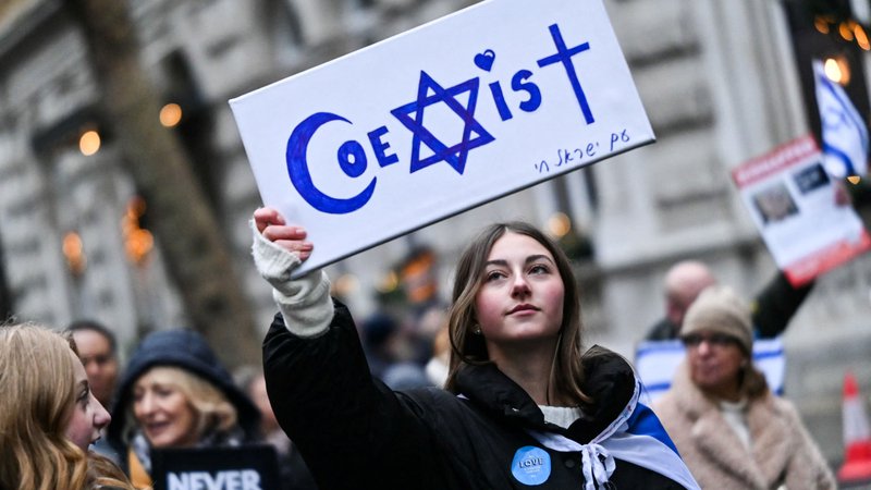 Fotografija: Protestnica med demonstracijami v središču Londona v znak protesta proti antisemitizmu drži napis »Sožitje«. Foto: Justin Tallis/Afp