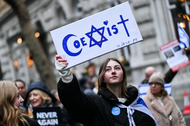 Protestnica med demonstracijami v središču Londona v znak protesta proti antisemitizmu drži napis »Sožitje«. Foto: Justin Tallis/Afp