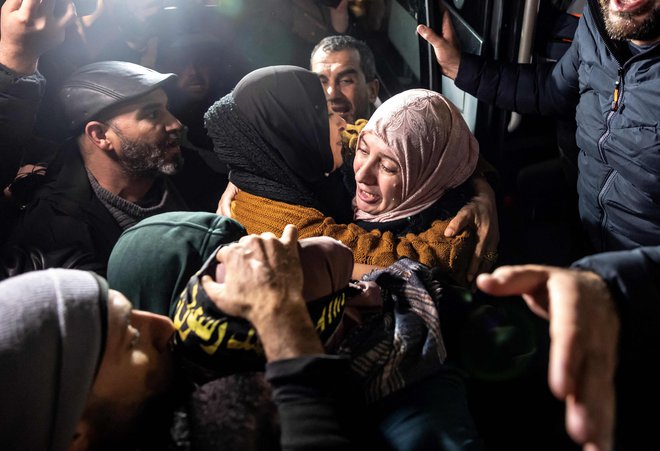 Palestinska zapornica objema sorodnico, potem ko so jo izpustili iz izraelskega zapora v zameno za izraelske talce. FOTO: Fadel Senna/AFP