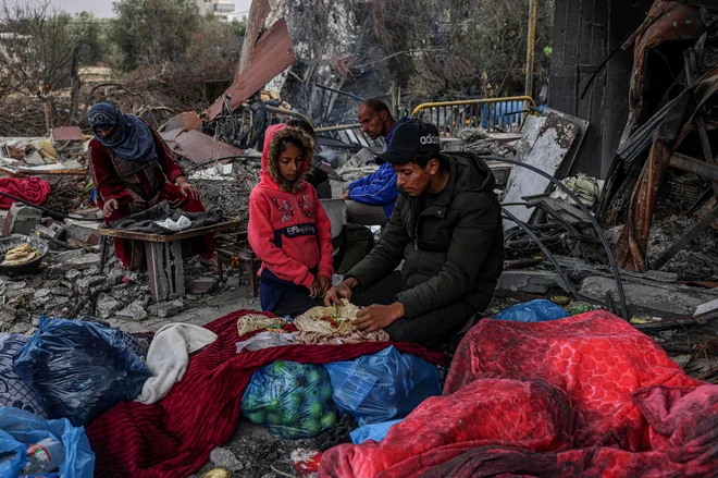 Palestinci pripravljajo obrok v porušeni vasi Khuzaa vzhodno od Khan Yunisa, blizu mejne ograje med Izraelom in južno Gazo, med premirjem v spopadih med Izraelom in palestinsko militantno skupino Hamas. Izraelska vlada je danes sporočila, da je Hamas opozorila, da je možnost podaljšanja premirja na območju Gaze odprta. Foto: Said Khatib/Afp