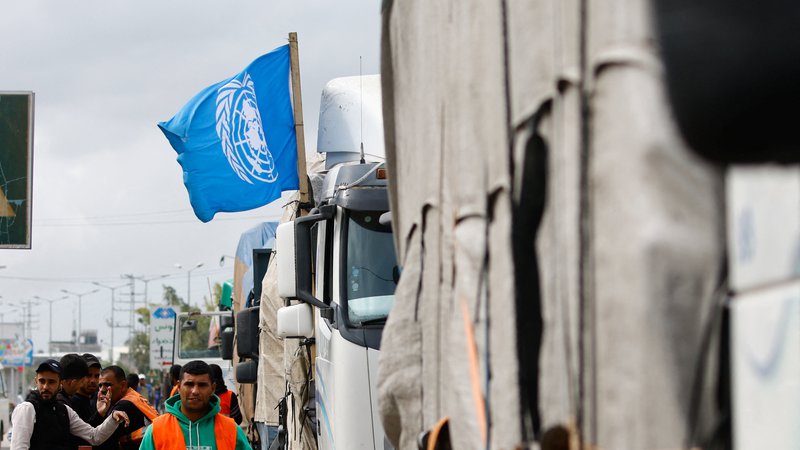 Fotografija: Humanitarno pomoč na meji najprej raztovorijo, nato naložijo blago v tovornjake v organizaciji Združenih narodov, ki ga razvozijo po enklavi. FOTO: Ibraheem Abu Mustafa/Reuters