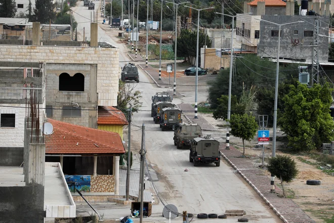 V torek so okupacijske sile ubile dva palestinska najstnika, nato pa znova vdrle še v Dženin, kjer od sinoči poteka racija z več sto vojaki, oklepnimi vozili, bagri in droni. FOTO: Raneen Sawafta/Reuters