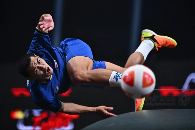 Tajec Phakpong Dejaroen vrača žogo proti Brazilcema Vanii Moraesu De Cruzu in Leonardu Lindosu De Almeidi med finalno tekmo mešanih dvojic na svetovnem prvenstvu v teqballu v Bangkoku. FOTO: Lillian Suwanrumpha/AFP